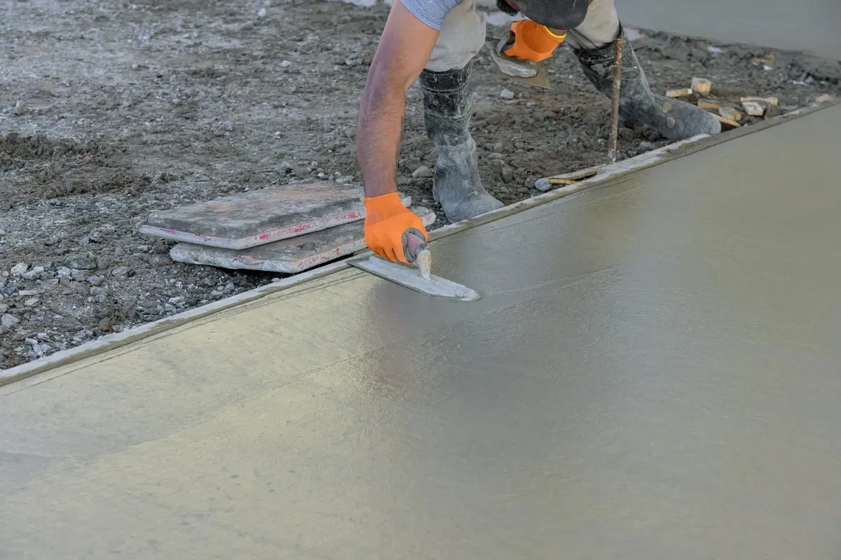 Trade partner screeding a freshly poured concrete base